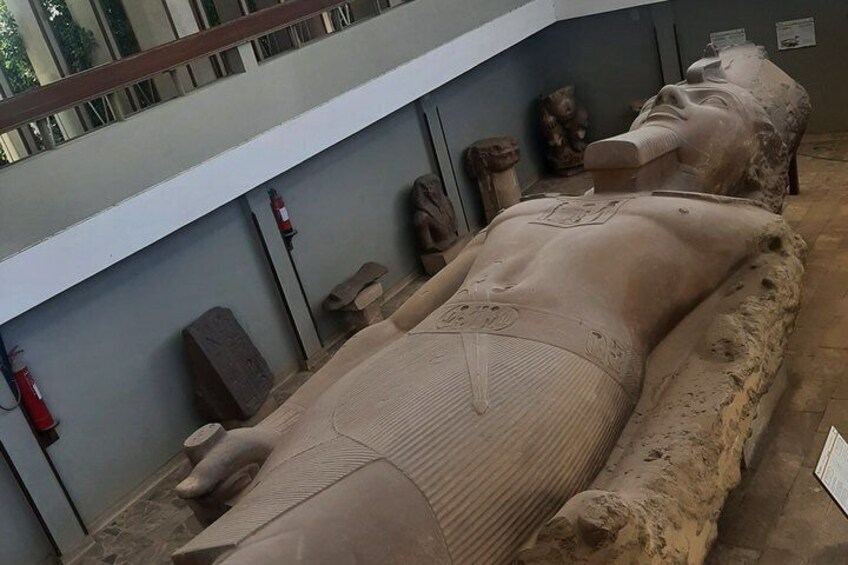 An ancient Egyptian sarcophagus with hieroglyphics, surrounded by stone blocks and artifacts. 5