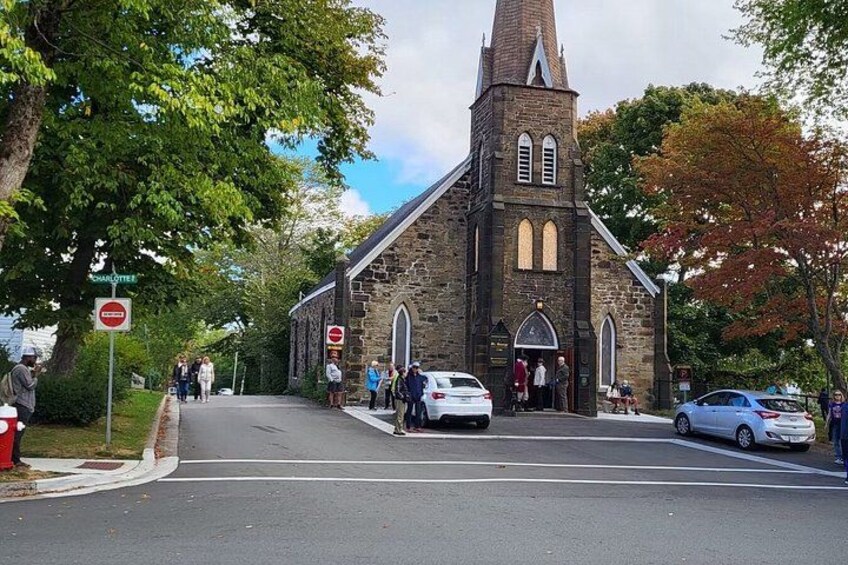 A church with a steeple, a stop sign, and a pedestrian crossing. 2
