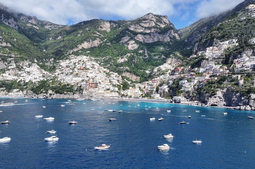 A coastal town with boats on the water and buildings on the hillside. 3