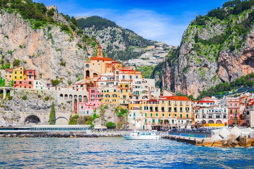 A coastal town with colorful buildings, a church, and a boat docked at the pier. 4