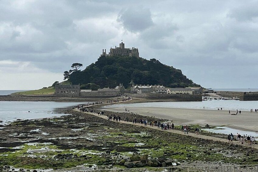 A castle on a hill, a beach, and a rocky shoreline. 1