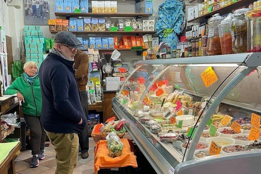 A deli with a glass display case filled with various food items. 4