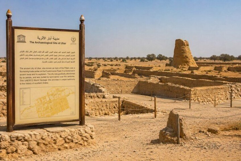 An archaeological site with ancient ruins and a signboard. 2