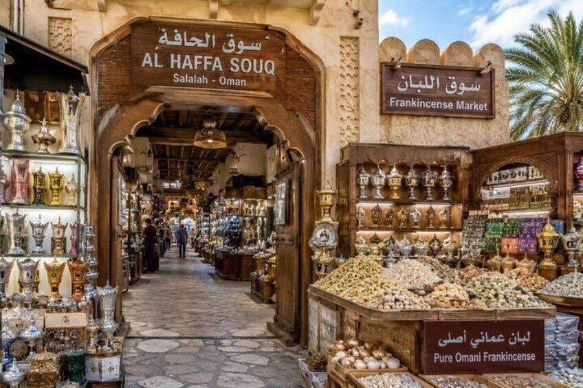 A market with ornate arches and a variety of goods, including pottery and jewelry. 2