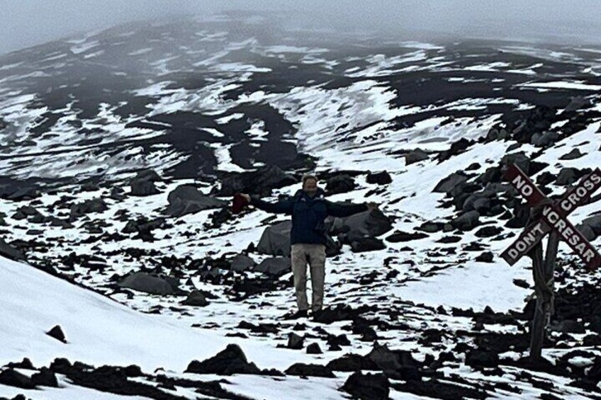 A person standing on a snowy mountain with a 'No Trespassing' sign. 4
