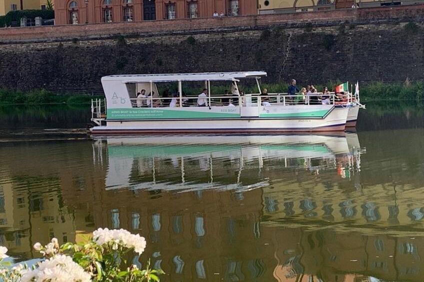 A boat with passengers, a calm river, and a stone wall in the background. 2