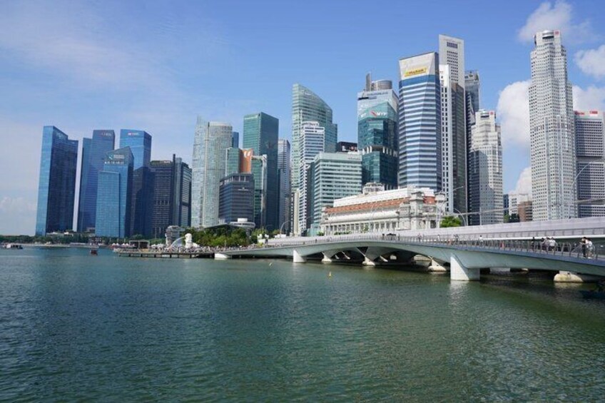A city skyline with modern skyscrapers, a bridge over water, and a clear sky. 3
