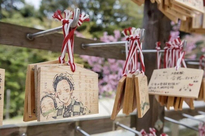 Wooden plaques with drawings and text, some with red and white ribbons. 3