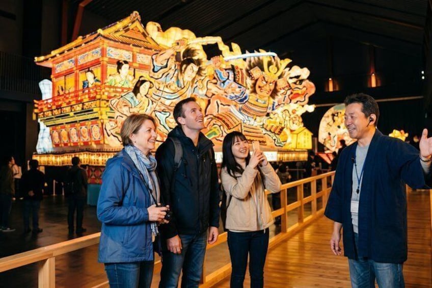 A group of people standing in front of a large, colorful traditional Chinese architectural structure. 1