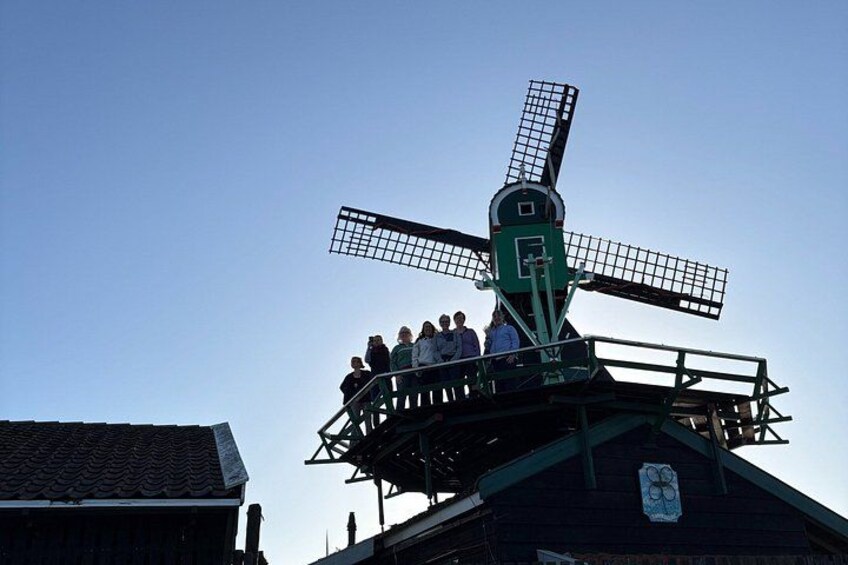 A windmill with a platform where people are standing. 3