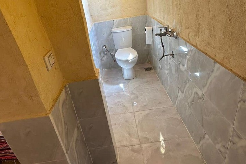A bathroom with a toilet, a sink, and a mirror. 4