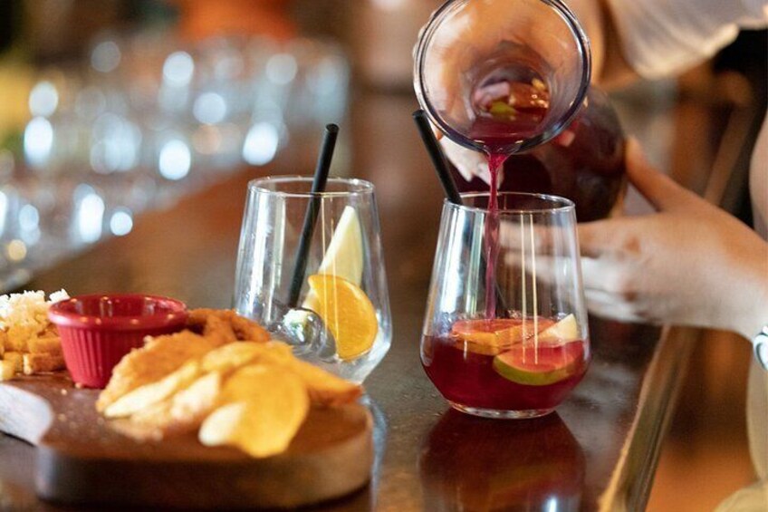 A person pouring a red drink into a glass with a lemon slice and a straw. 1