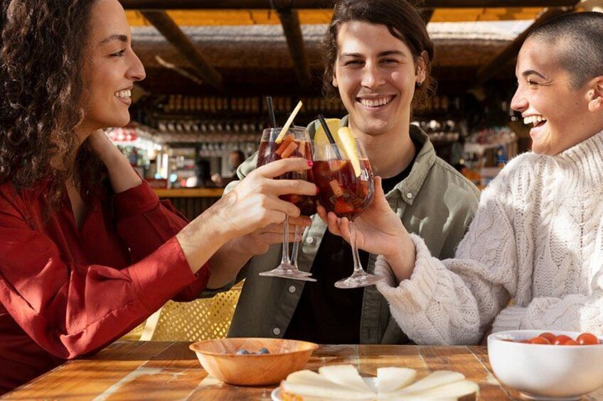 Three people toasting with drinks at a bar. 3