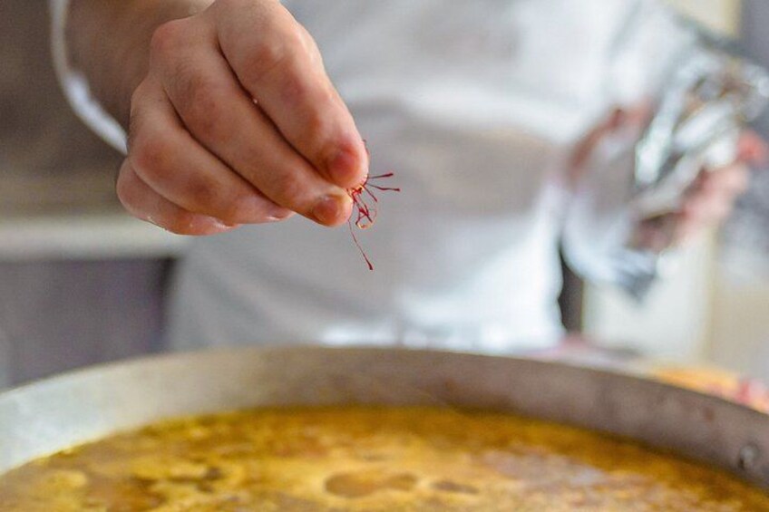A person holding a small object over a pot of food. 5