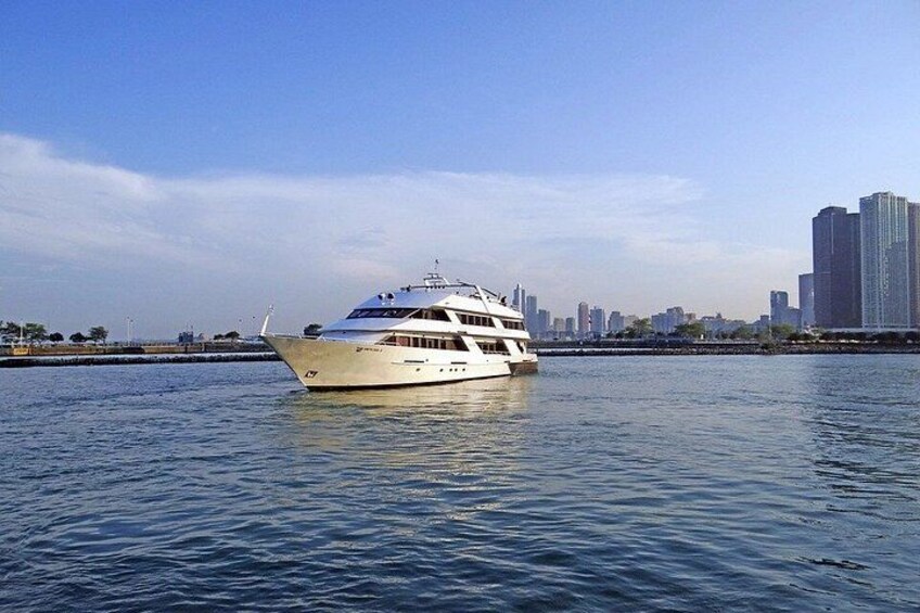 A large white yacht on calm water with a city skyline in the background. 5