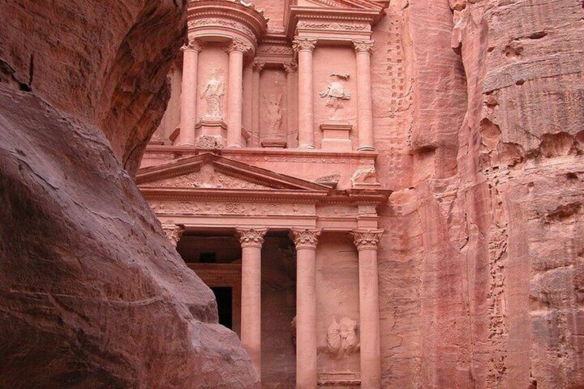 A carved rock facade with columns and a central relief sculpture. 3