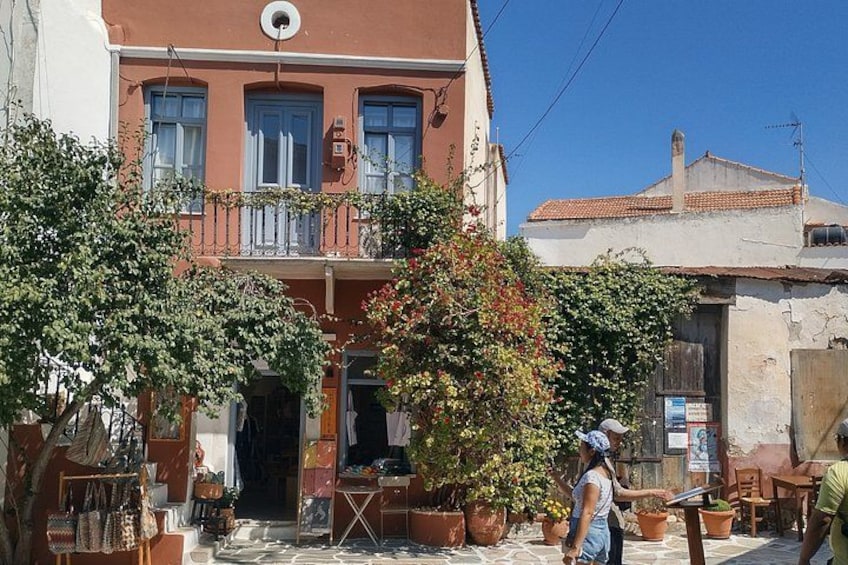 A red building with a balcony, potted plants, and a clear blue sky. 4
