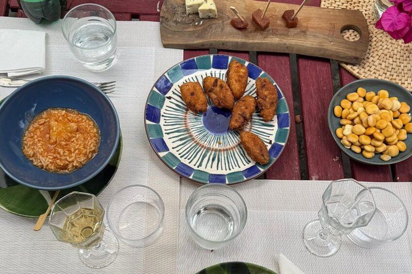 A table with food items, including a bowl of pasta, a plate of fried chicken, and a bowl of corn. 5