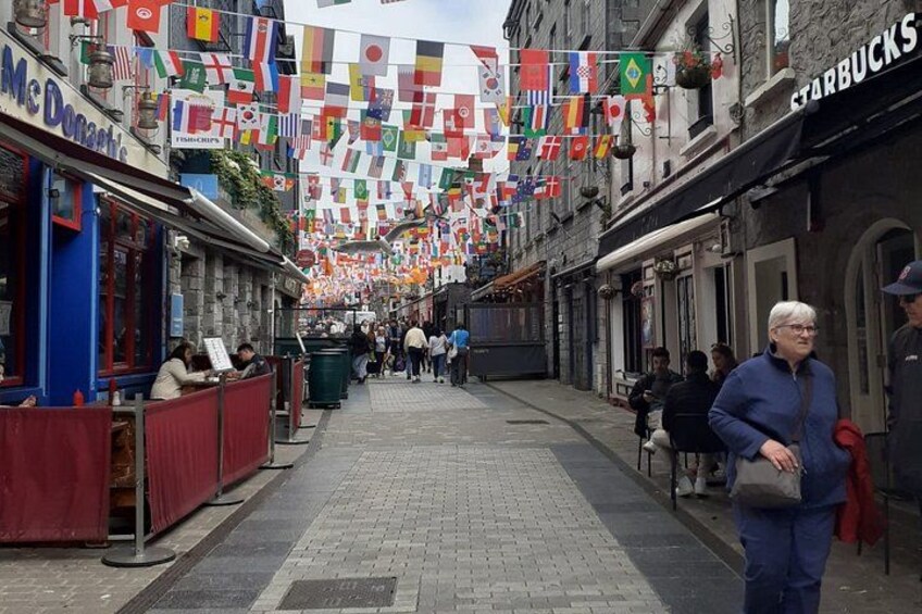 A street with shops, including a McDonald's and Starbucks, and flags hanging overhead. 2