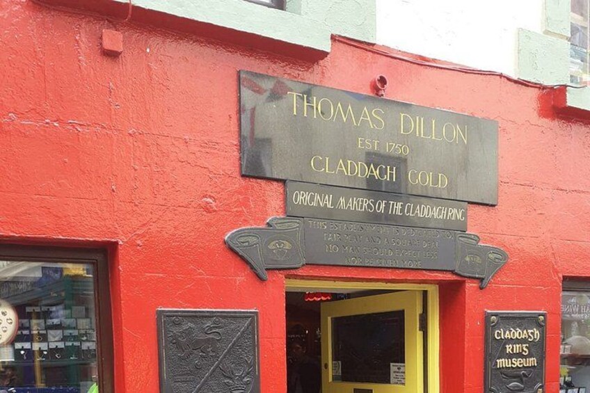 A red building with a sign for Thomas Dillon Claddagh Gold, established in 1750, and a plaque for Claddagh Ring Museum. 3