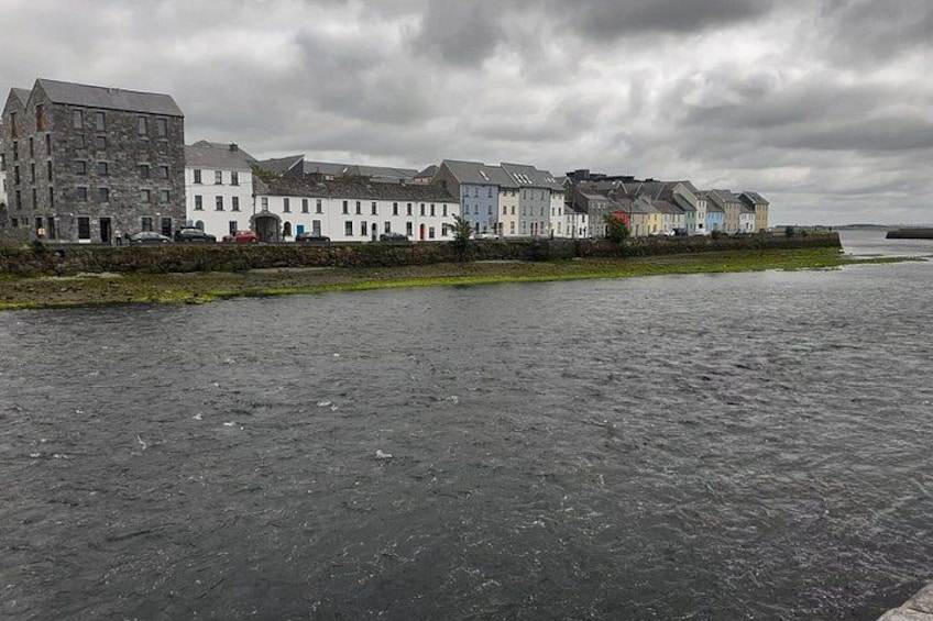 A waterfront with buildings and a cloudy sky. 1