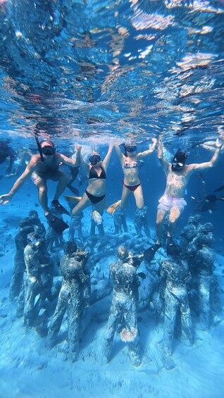 Underwater divers swimming in a clear blue ocean with coral formations. 3