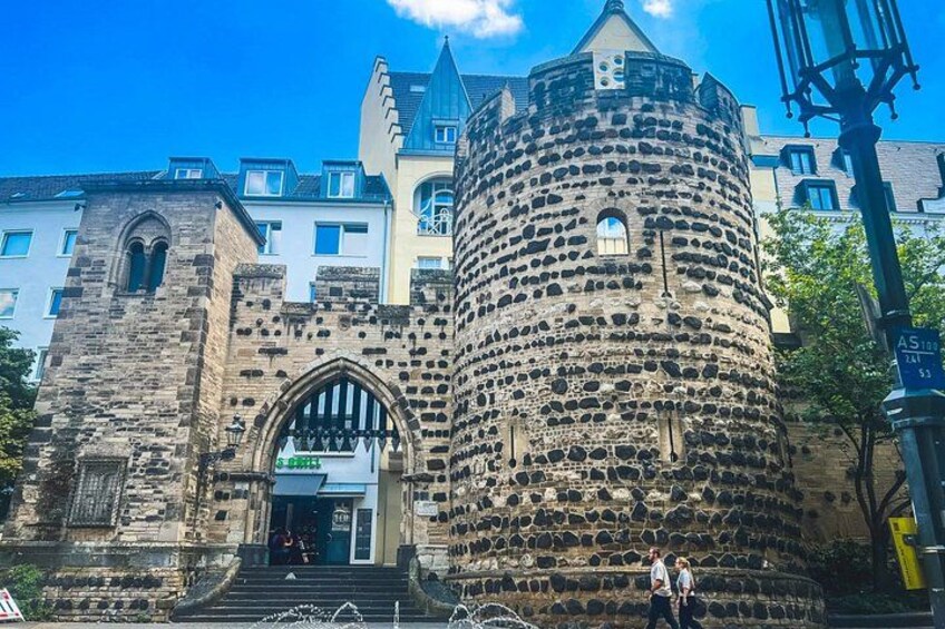 A historic stone tower with a rounded top and a large arched entrance. 2
