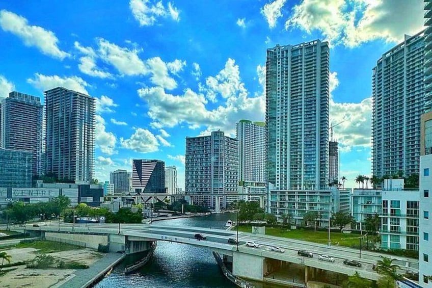 A cityscape with high-rise buildings, a river, and a bridge. 5