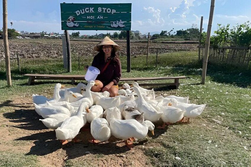 A person sitting among ducks at Duck Stop. 4