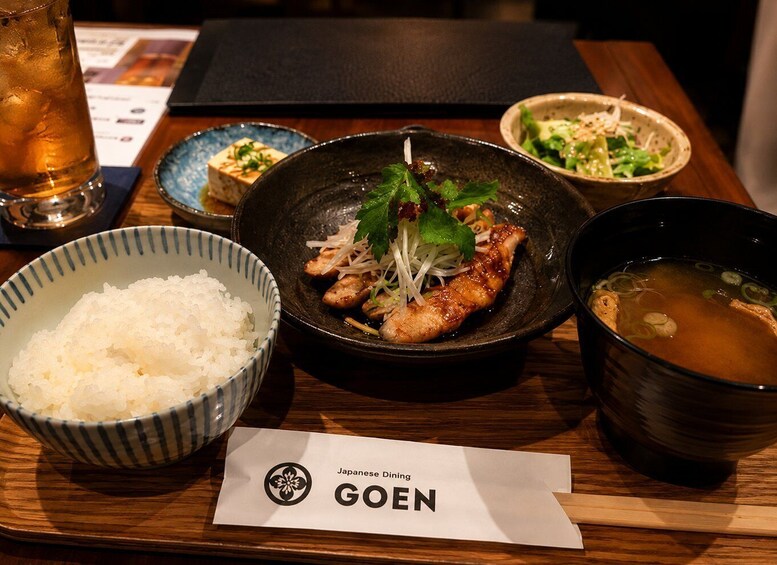 A meal with rice, a bowl of soup, and a plate with meat and vegetables. 5