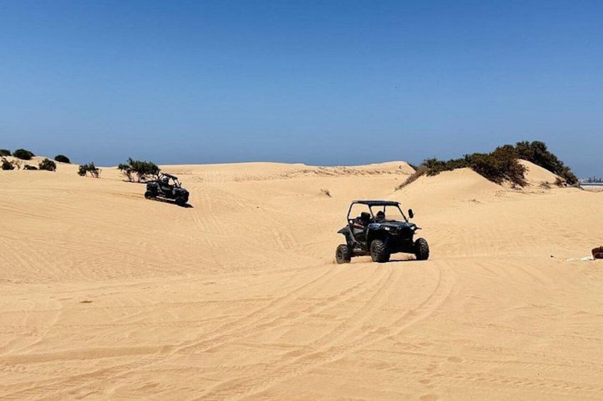 A desert landscape with sand dunes and off-road vehicles. 5