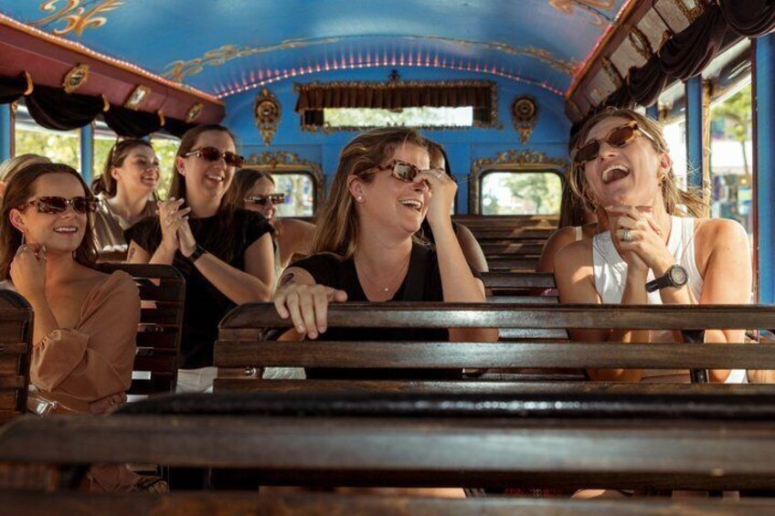 A group of people on a vintage train with ornate blue and gold decorations. 3