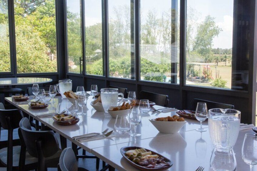 A dining table set with plates, glasses, and a pitcher, overlooking a scenic outdoor area. 4