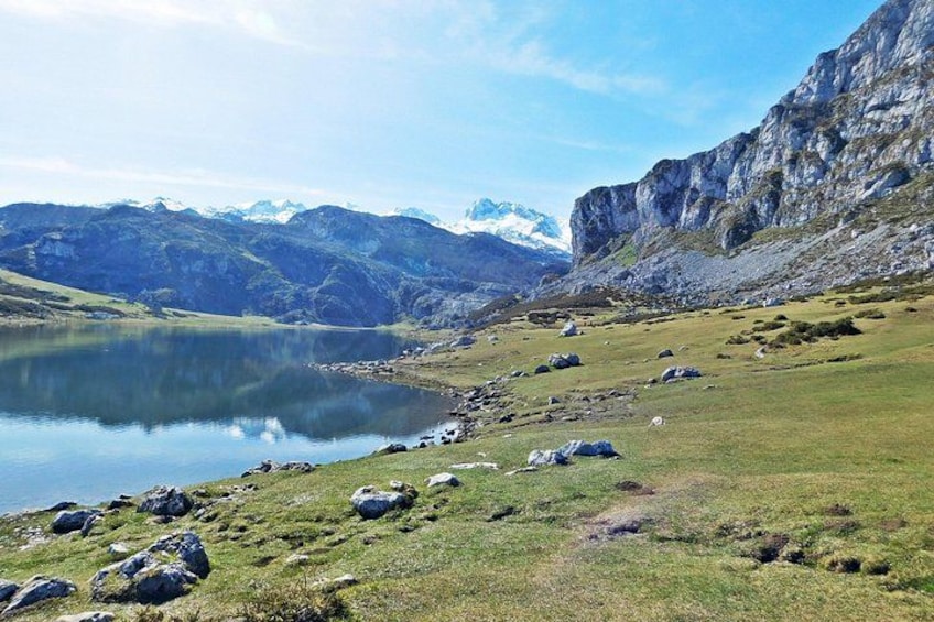 A mountain landscape with a lake, rocky terrain, and snow-capped peaks. 3