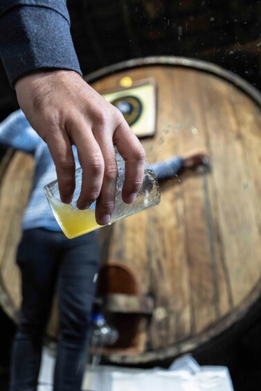 A hand pouring a yellow liquid into a glass. 3