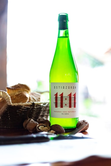 A green bottle labeled '1111' with a white label, placed on a table with bread and walnuts. 4