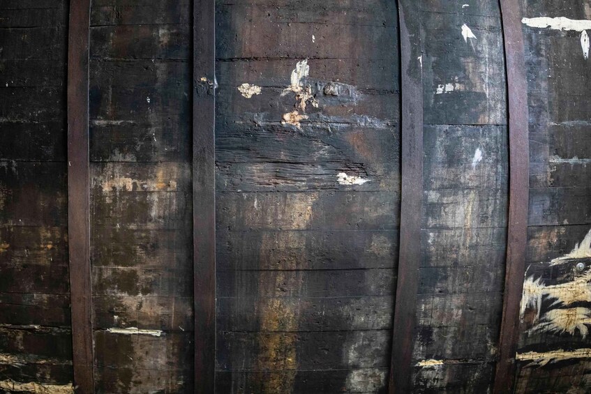 A weathered wooden wall with peeling paint and visible damage. 2