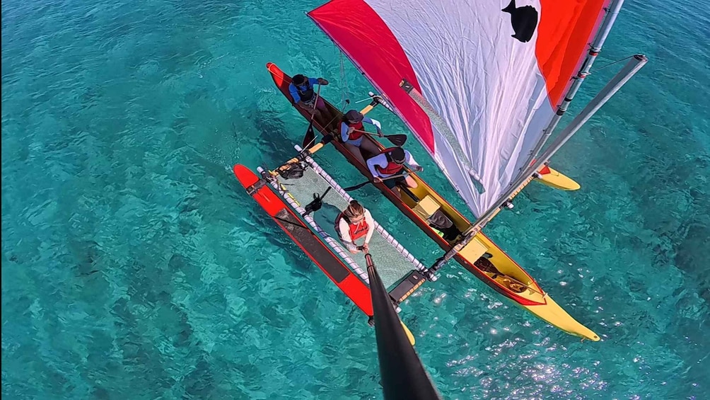 A person paddling a canoe on clear turquoise water. 5