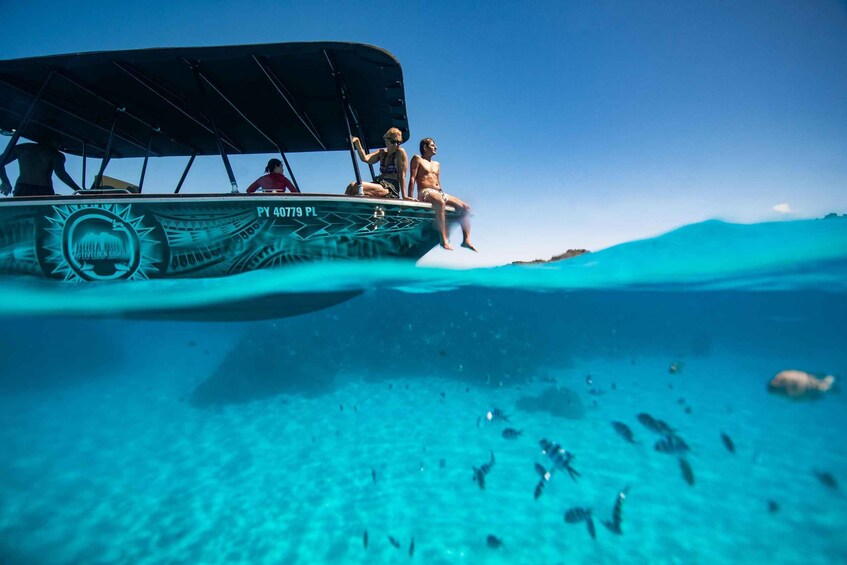 A boat with people on it, partially submerged in clear blue water. 4
