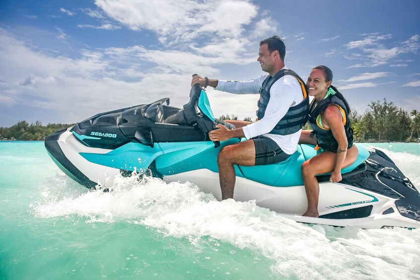 A person riding a jet ski on turquoise water with a clear sky. 2