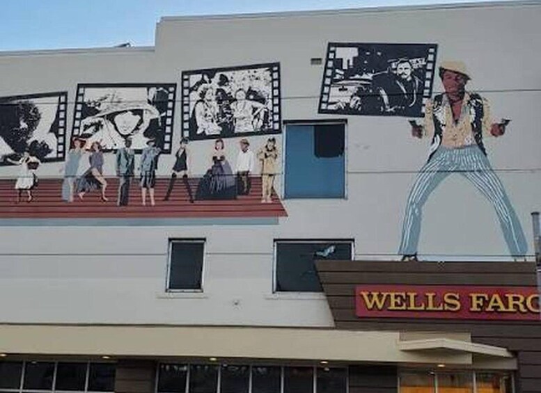 A building with a large mural of people dancing and a Wells Fargo sign. 3