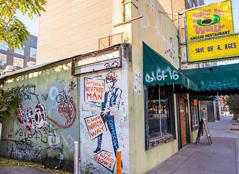 A building with graffiti and a sign for an arcade restaurant. 2