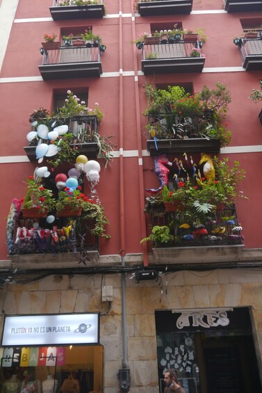A building with balconies adorned with plants and balloons. 5