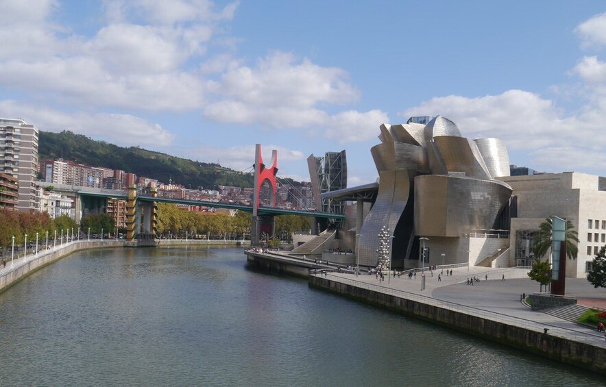 A river with a modern bridge and a distinctive metallic building. 4
