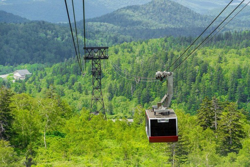 A cable car system in a mountainous area with dense green forests. 4