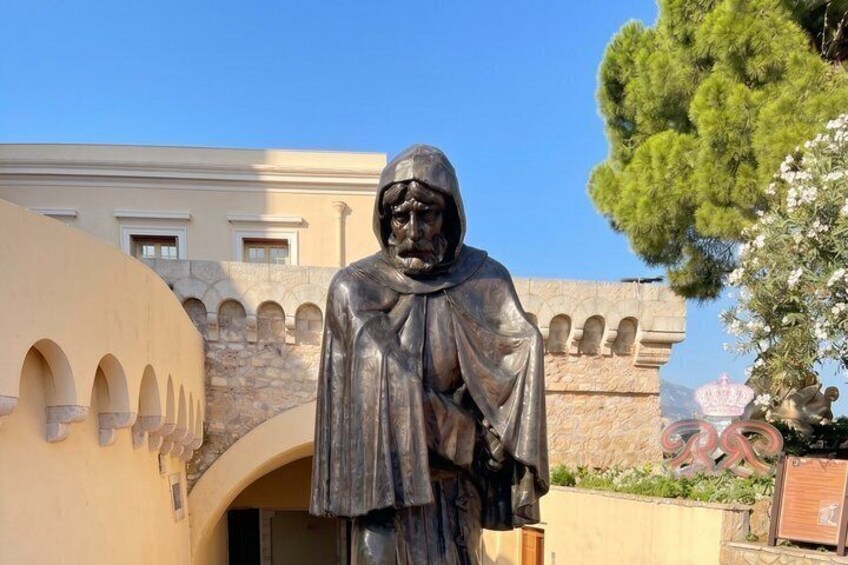 En statue i en gård med en bygning i baggrunden. 2