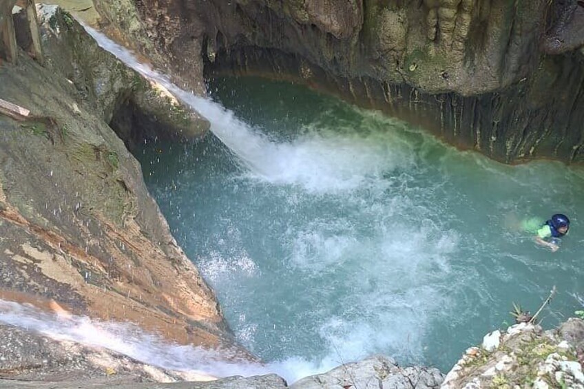 A person surfing in a natural water body with rocky surroundings. 5
