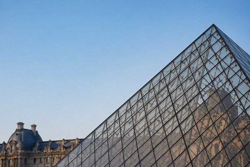 A large glass pyramid structure with a clear sky in the background. 4
