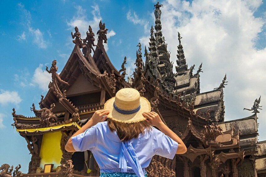 A person taking a photo of a temple with intricate architecture. 1