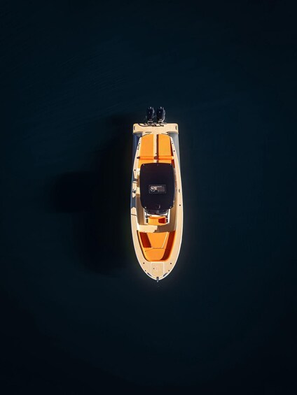 A small orange boat on calm water. 4